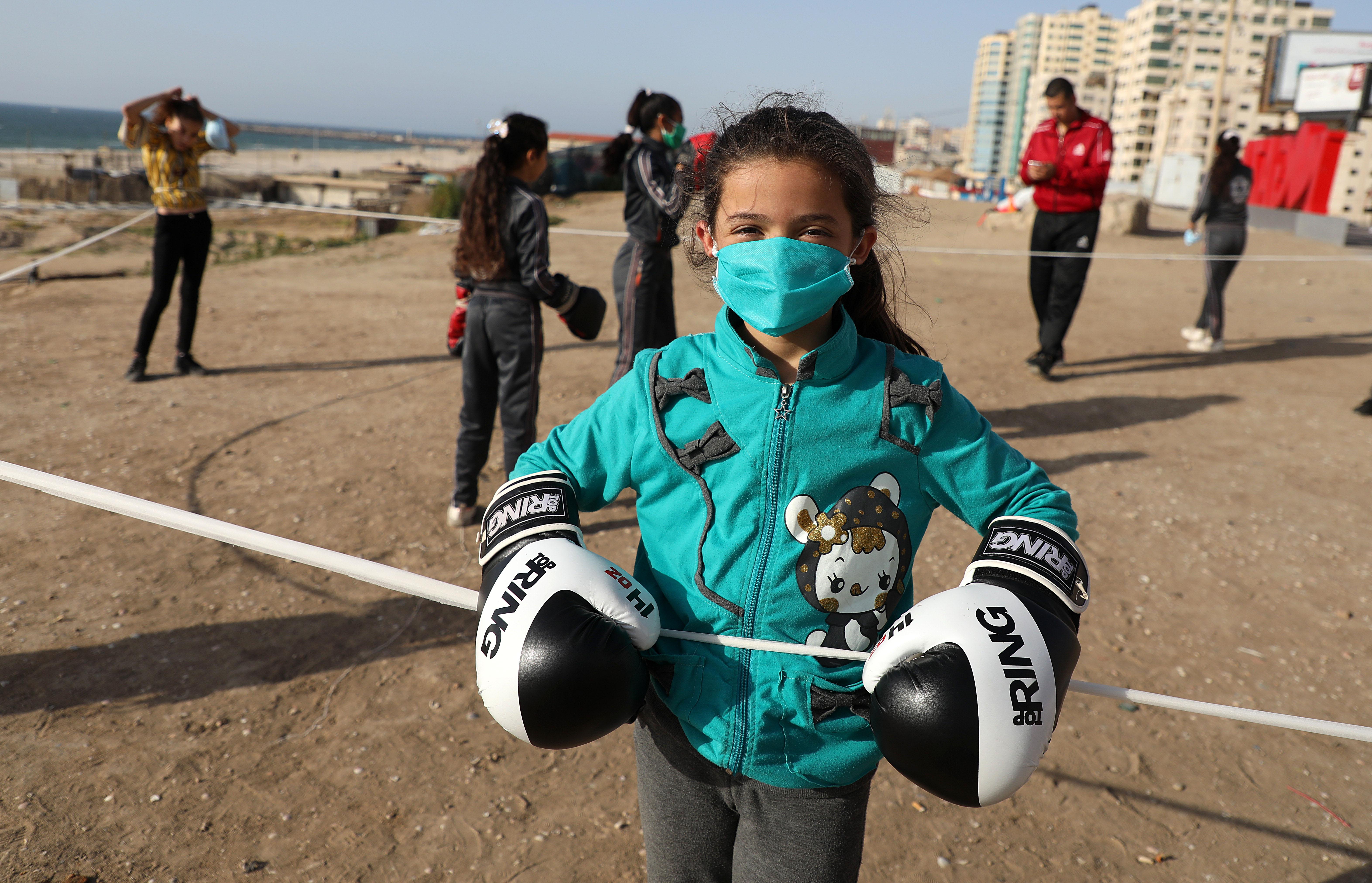 Palestinian girls clad in masks due to the COVID-19 coronavirus pandemic take part in an open-air boxing training near the beach in Gaza City on May 12, 2020. (Photo by Majdi Fathi/NurPhoto via Getty Images)