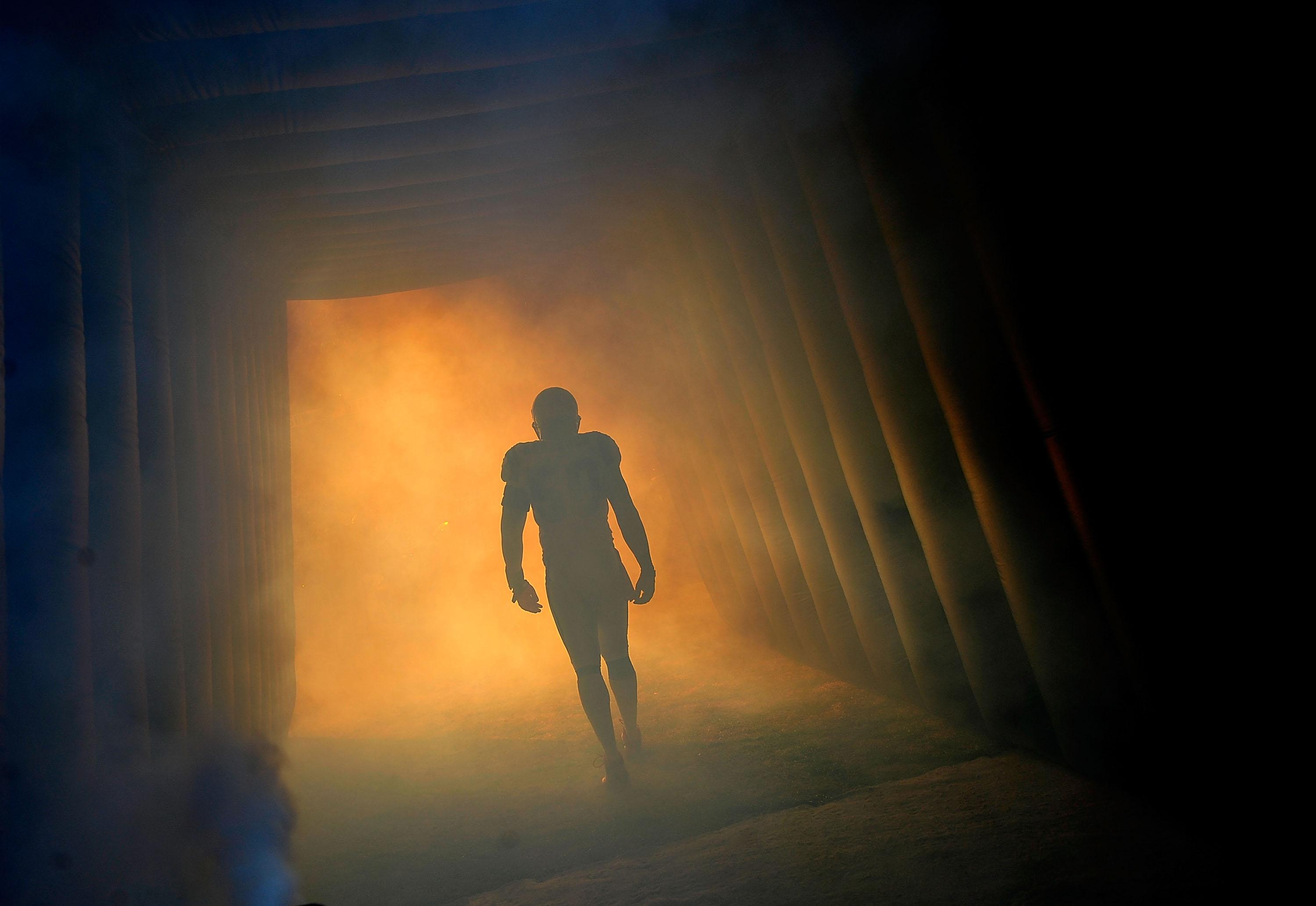 Football player running through tunnel