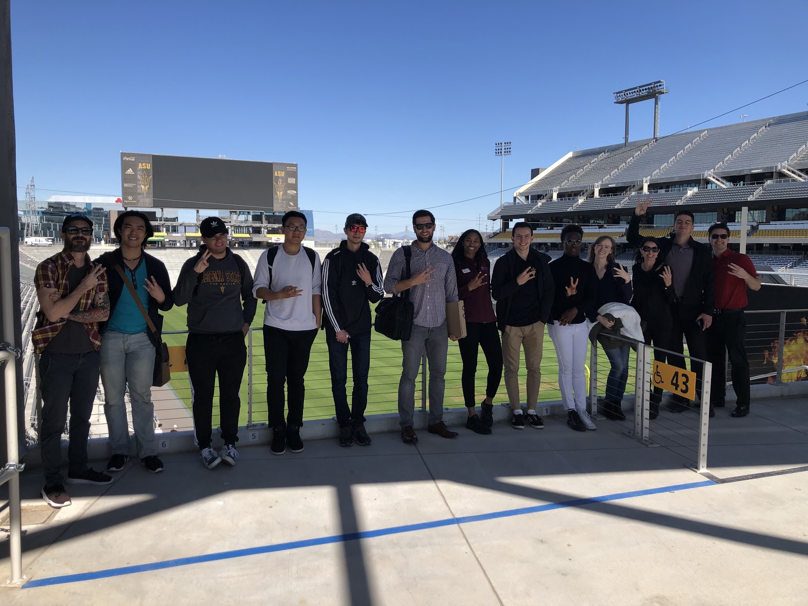 Students on the tour pose on the main concourse at Sun Devil Stadium with the scoreboard in the background