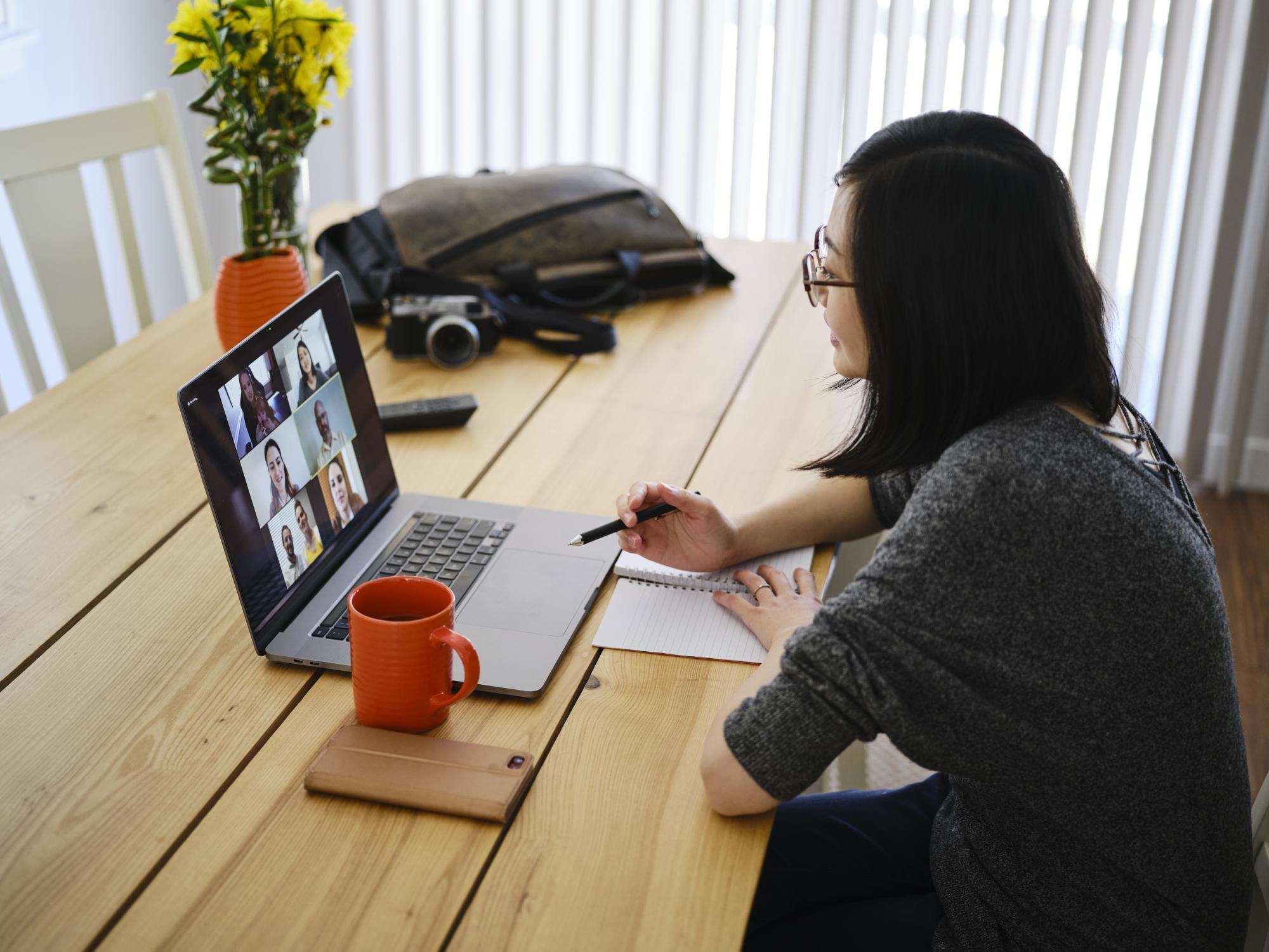 A woman working at home participating in a online web meeting.