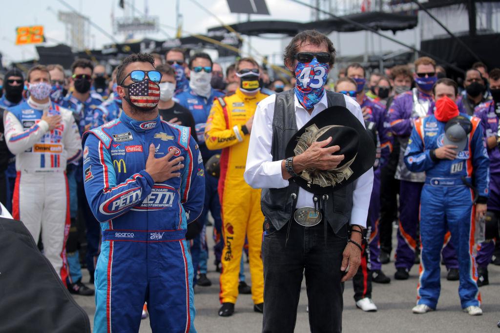  Bubba Wallace, driver of the #43 Victory Junction Chevrolet, and team owner, and NASCAR Hall of Famer Richard Petty stand for the national anthem prior to the NASCAR Cup Series GEICO 500 at Talladega Superspeedway on June 22, 2020 in Talladega, Alabama. 
