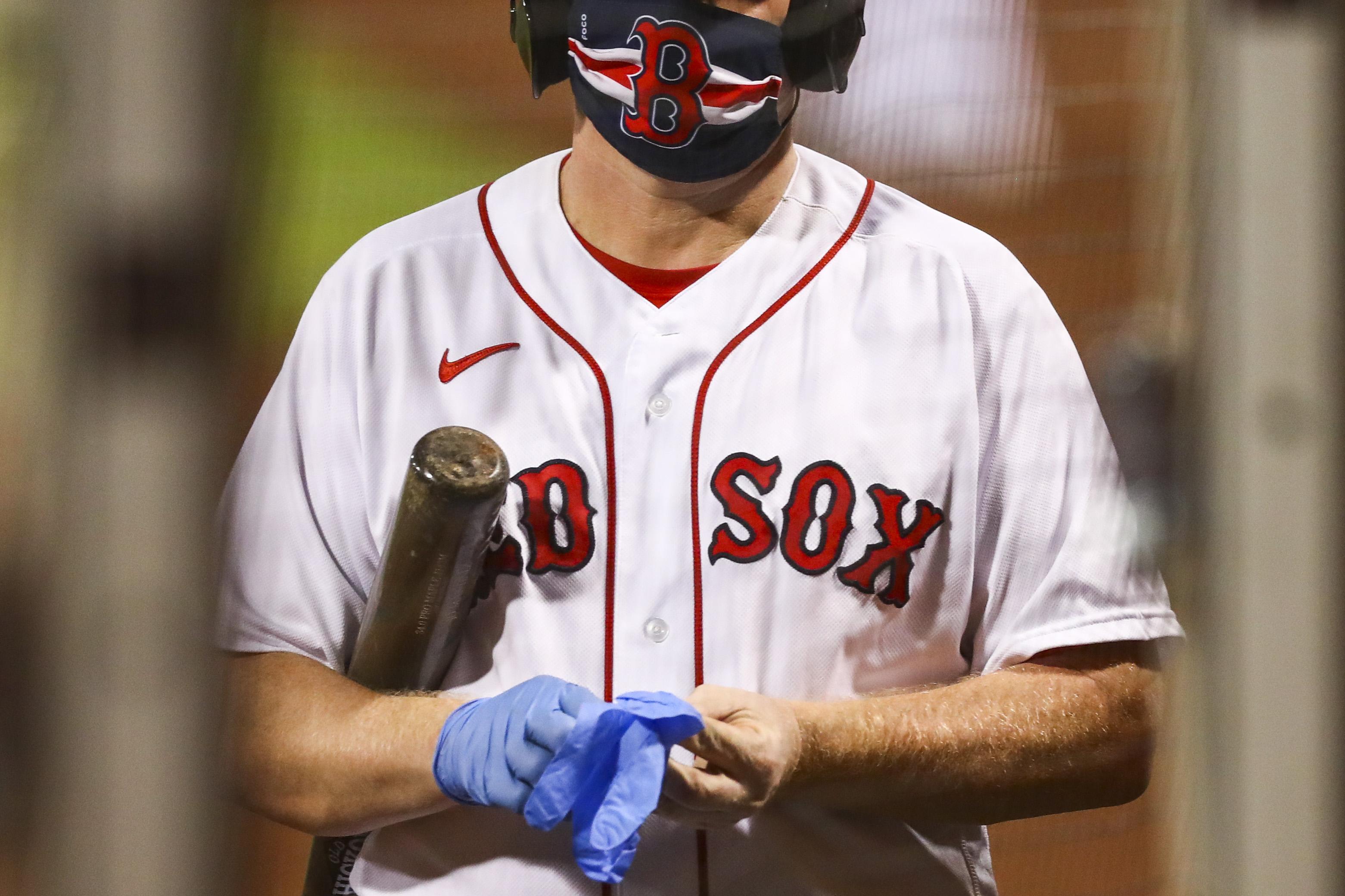 BOSTON, MA - JULY 28: The ball boy wears a protective face mask as he puts on medical latex gloves during the sixth inning of a game between the Boston Red Sox and the New York Mets at Fenway Park on July 28, 2020 in Boston, Massachusetts. 